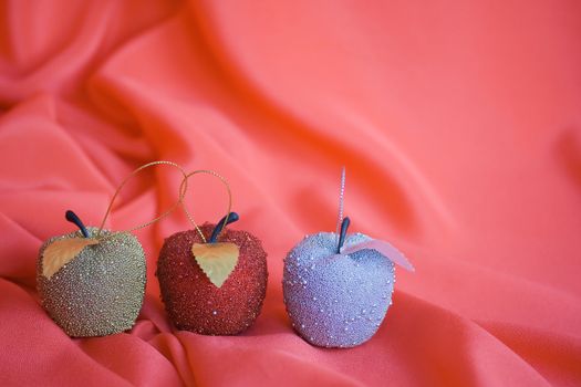 Three christmas tree apples on red background