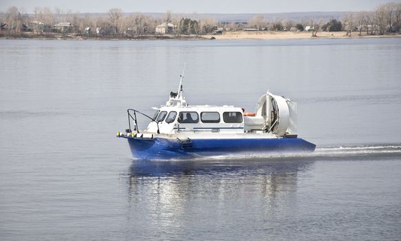 Hovercraft rides on the water, creating splashes.