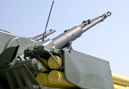 Turret with two large caliber machine guns aimed at blue sky. Close-up.