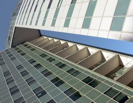 The glass facade of a skyscraper with the curtain walls on a background of blue sky.