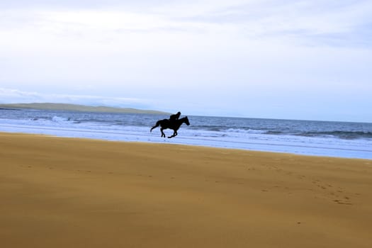 horse riding on ballybunions beach shore on irelands west coast