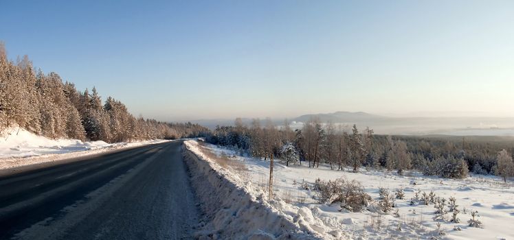 Desert ice the winter road in the mountains of the Urals. A lot of snow and forest.
