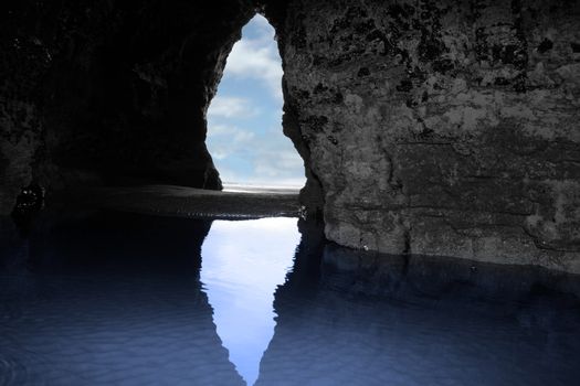 a view from the inside of a beach cave looking out at the sea