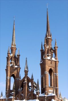 Gothic cathedral with a bell tower against the blue sky.