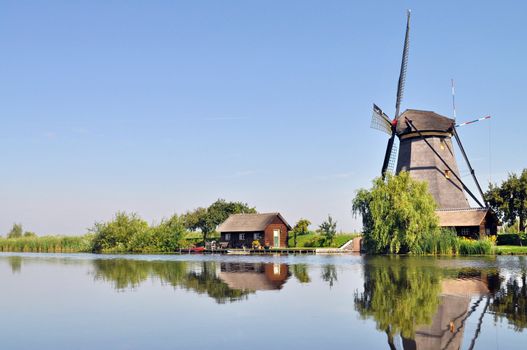 Mill and house reflecting into a dutch canal