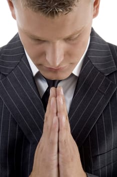 praying young businessman against white background