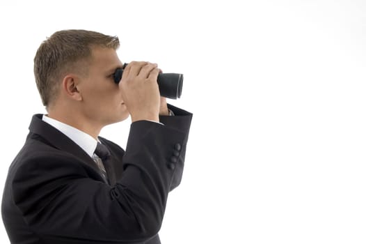 handsome young businessman using a pair of binoculars against white background