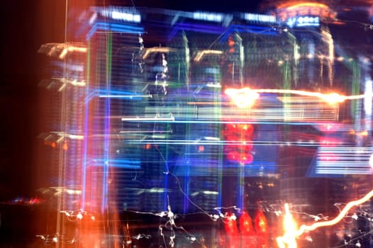 Shanghai city by night, blured neons and skyscrapers with different colorful reflections.