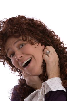 Mature woman with long curly brown hair looking happy