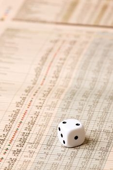 A dice sitting on a stock market chart