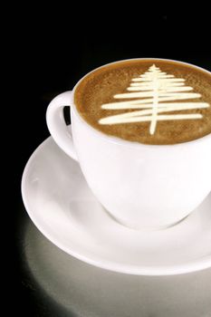 A cappuccino with a christmas tree in latte art