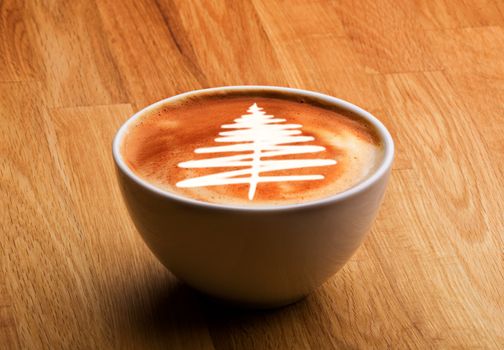 A cappuccino with a christmas tree in latte art
