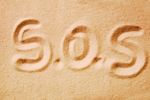 S.O.S. written in golden sand - distress message