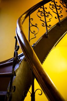 An abstract image of an old stairwell and railing with decorative iron.