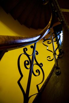An abstract image of an old stairwell and railing with decorative iron.