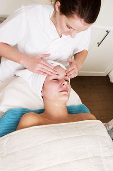 Lotion being massaged into face a beauty spa.