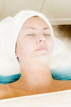 Relaxing during a facial steam treatment at a beauty spa.