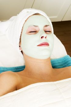 Relaxing with a green apple facial mask at a beauty spa.