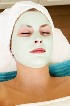 Relaxing with a green apple facial mask at a beauty spa.