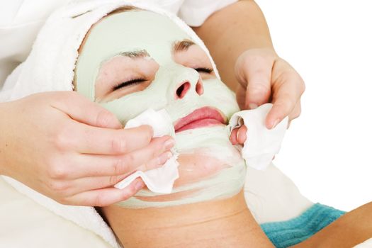 Detail of a facial mask treatment being wiped off the face.