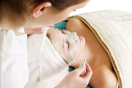 Detail of a facial mask treatment being wiped off the face.