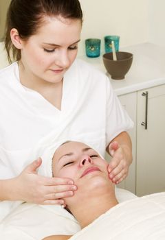 A woman receiving a facial massage at a beauty spa.