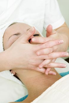 A woman receiving a facial massage at a beauty spa.