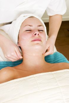 A woman receiving a facial massage at a beauty spa.