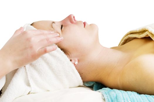 A woman receiving a facial massage at a beauty spa.