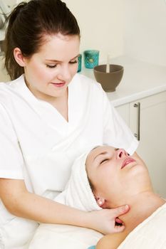 A woman receiving a facial massage at a beauty spa.