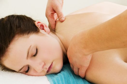 A close up image of a woman receiving a shoulder and back massage.