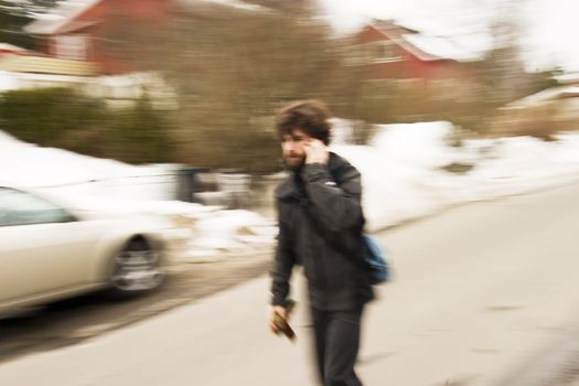 A motion blur abstract of a person walking in a hurry talking on a cell phone, a late rushing concept image.