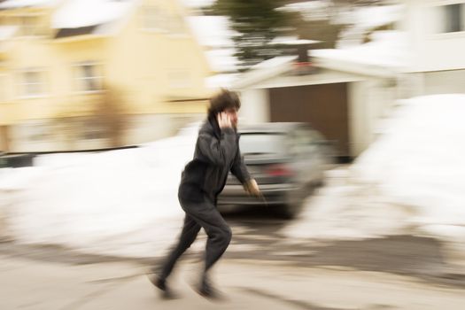 A motion blur abstract of a person walking in a hurry talking on a cell phone