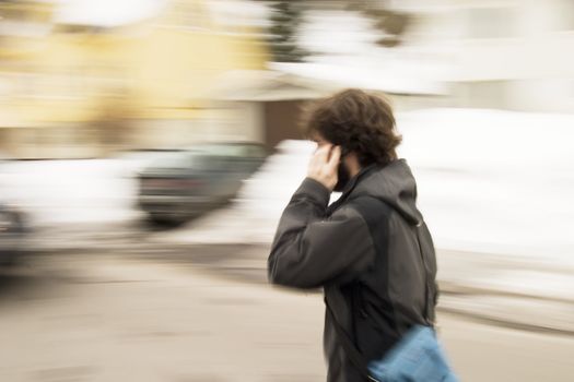 A motion blur abstract of a person walking in a hurry talking on a cell phone