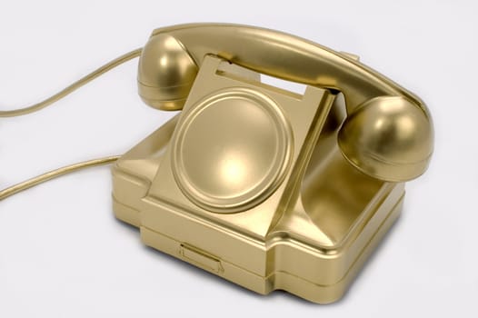 The telephone of gold colour on a white background.