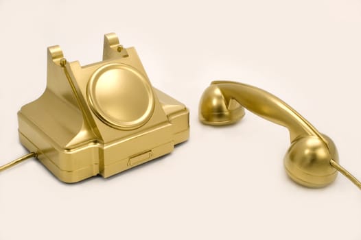 The telephone of gold colour on a white background.