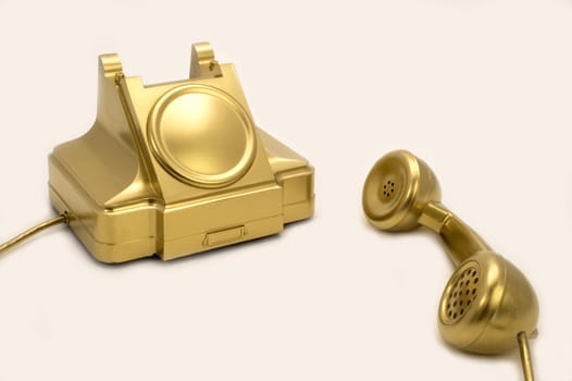 The telephone of gold colour on a white background.