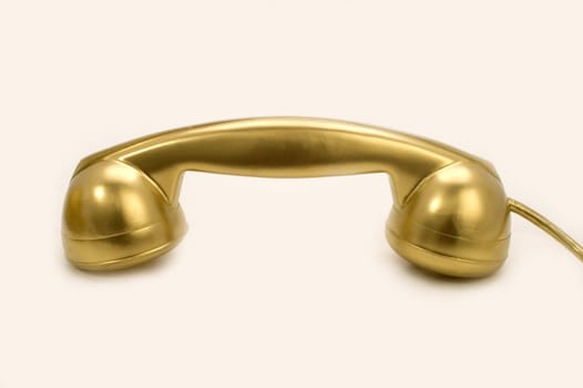 The telephone of gold colour on a white background.