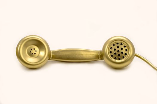 The telephone of gold colour on a white background.