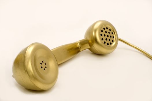 The telephone of gold colour on a white background.