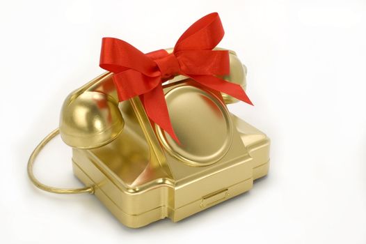 The telephone of gold colour with a red tape on a white background.