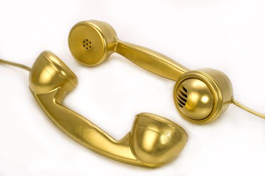 Two telephones of gold colour on a white background.