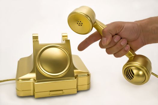 The telephone of gold colour on a white background.