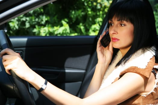 Girl with the phone in the automobile