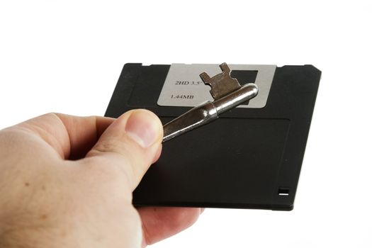A 3 1/2" computer disk being held in the hand of a male with a skeleton key.  Isolated on white with clipping path.