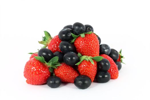 Heap of sweet strawberries and blueberries isolated on white