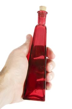 A male hand holding red glass bottle isolated on white with clipping path. Love potion number nine.