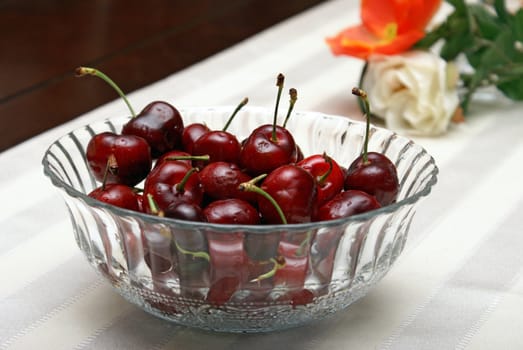 A bowl of fresh cherries on a nice setting.