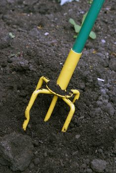 A closeup shot of a hand tiller working the dirt around.