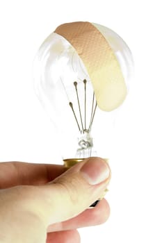 A light bulb with an adhesive bandage on it.  Isolated on white with clipping path.